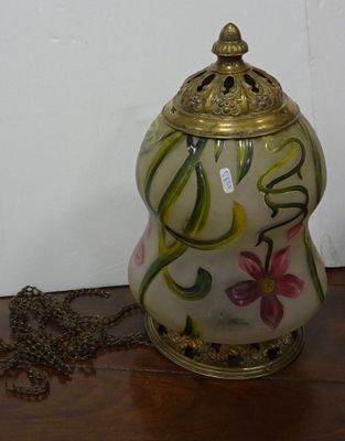 a vase with a chain on a table next to a wall