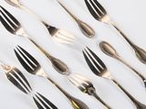a lot of forks and spoons on a white surface
