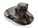 statue représentant un ours assis sur un rocher, posée sur un fond blanc