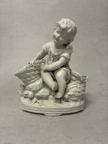 Sculpture en biscuit un décor d'un enfant aux paniers. Non signé