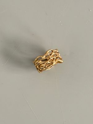 une bague en or munie d'une chaîne, posée sur une table