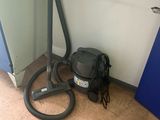 a vacuum and a bag on the floor next to a door