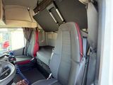 the interior of a white van with red seats and a steering wheel