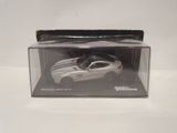 a white toy car in a clear box on a table