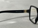 black and gold rimmed glasses with clear lens lenses on a white surface