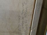 a picture of a picture of someone writing on a piece of wood
