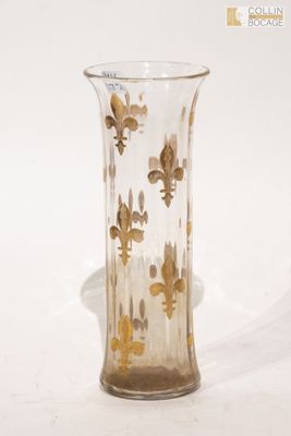 un vase en verre orné de fleurons dorés sur un fond blanc