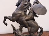 statue of a man on a horse holding a shield and shield