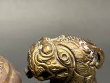 bronze figurine of a monkey holding a bowl with a lid