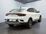 the rear end of a white car parked in a garage