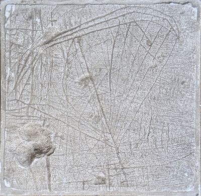 cement block with a drawing of a leaf on it on a sidewalk