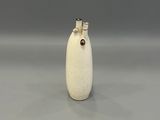 un petit vase blanc surmonté d'une fleur