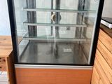 a glass display case with a clock inside of it
