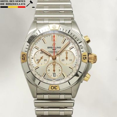 une montre argentée et dorée sur fond blanc