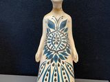 figurine en céramique représentant une femme dont le corps est orné d'un motif bleu et blanc