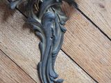 a close up of a wall mounted clock on a wooden floor