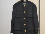 Le manteau est suspendu à un porte-vêtements dans la pièce.