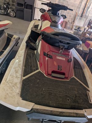 a red and white boat and a red and black boat in a garage