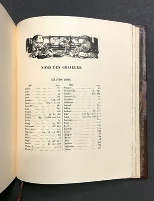 un livre ouvert sur lequel figure une image en noir et blanc représentant un groupe de personnes assises à une table