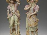pair of figurines of a woman and a man with hats