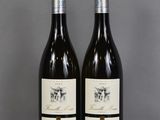 two bottles of wine sitting on top of a table next to each other