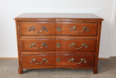 une commode en bois avec un plateau en marbre, posée à même le sol