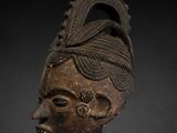 a wooden mask with a black background and a black background