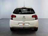 the rear end of a white citrole parked in a white room