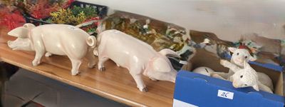 trois figurines de cochons posées sur une étagère dans une pièce