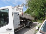 a white truck with a flat bed parked next to a white car