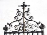 a wrought iron bed frame with a cross on top of it