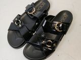 pair of black sandals with gold buckles on a white surface