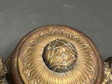 a gold vase with a lion head on top of it