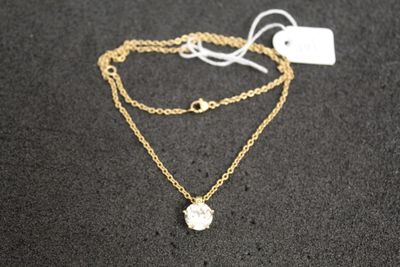 un collier à chaîne en or orné d'une pierre blanche