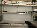 une cuisine équipée d'un réfrigérateur et d'un plan de travail sur lequel sont posés de la vaisselle