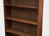 a large wooden bookcase with four shelves on top of it