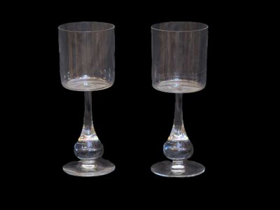 pair of clear glass goblets on a black background