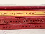three red books stacked on top of each other on a white surface