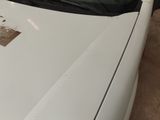 a white car that has a sticker on the hood of it