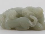 a picture of a jade sculpture of elephants on a white surface