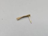 a close up of a gold ear pin on a white surface