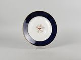 a close up of a plate on a stand on a white surface