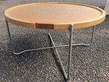 une table en bois avec des pieds en métal, sur laquelle est posé un plateau en bois