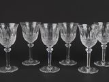 a set of six crystal wine glasses on a black background