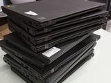 Plusieurs ordinateurs portables sont empilés les uns sur les autres sur une table