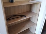 a closet with a shelf and a mirror on the wall