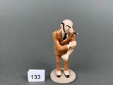 une petite figurine représentant un homme tenant une batte de baseball
