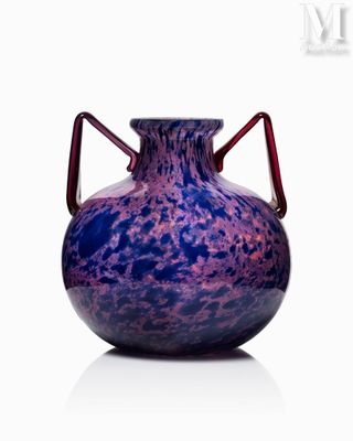 a purple vase with a red handle sitting on a white surface