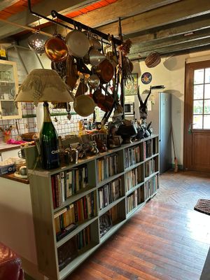 a kitchen with a book shelf and a refrigerator in it