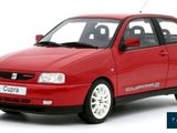 the small red car is parked on a white surface